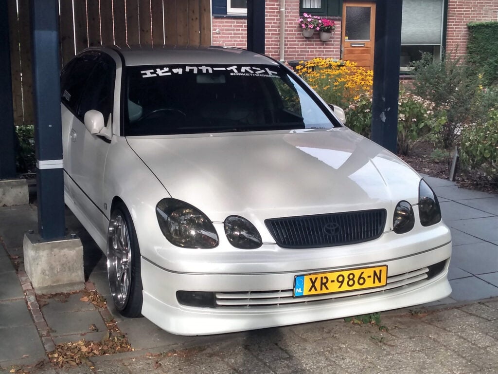A white car parked under a covered garage.