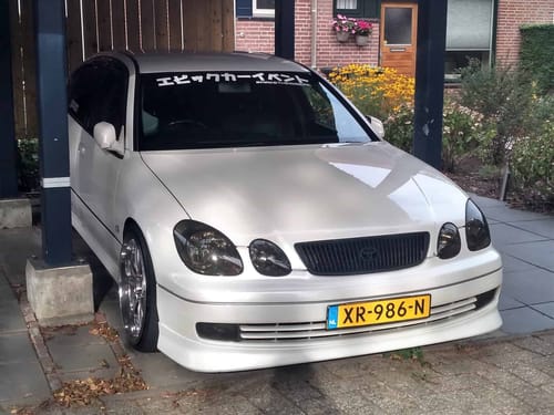 A white car parked under a covered garage.